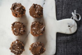 6 chocolate covered small round flapjacks on a marble chopping board