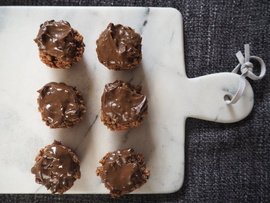 6 chocolate covered small round flapjacks on a marble chopping board