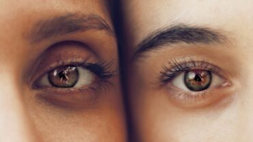Close up image of two people showing just one of their brown eyes