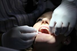 Close up of female face haveing her teeth and oral health checked by dentist