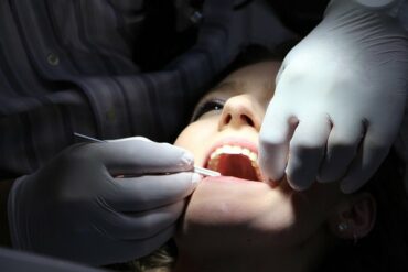 Close up of female face haveing her teeth and oral health checked by dentist