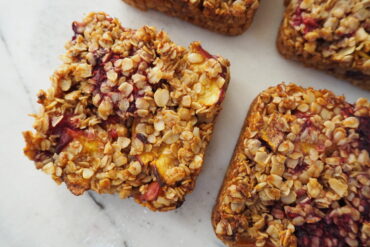 Close up of 4 square peach melba flapjacks on a white marble background