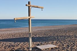 Wooden shower post on a hot beach