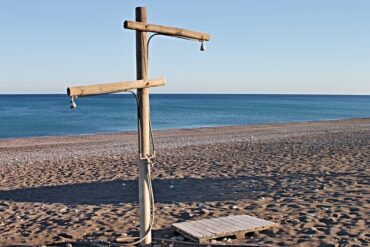 Wooden shower post on a hot beach