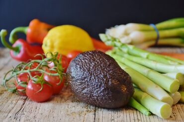 Selection of vegetables on a wooden chopping board demonstrating a vegan diet