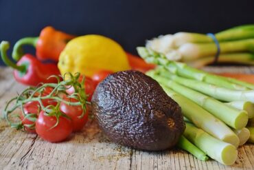 Selection of vegetables on a wooden chopping board demonstrating a vegan diet