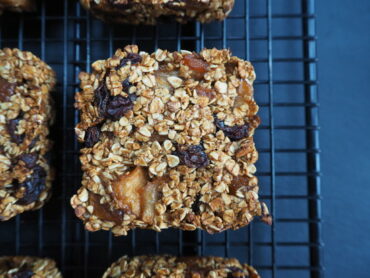 Close up of a square apple cinnamon and raisin flapjack on a wire cooling rack