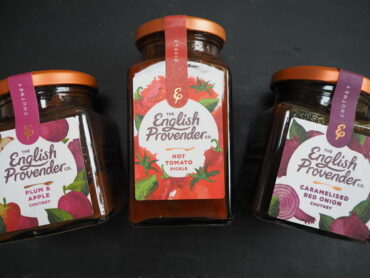 Three jars of The English Provender Co. chutneys and pickle laid down on a dark slate background