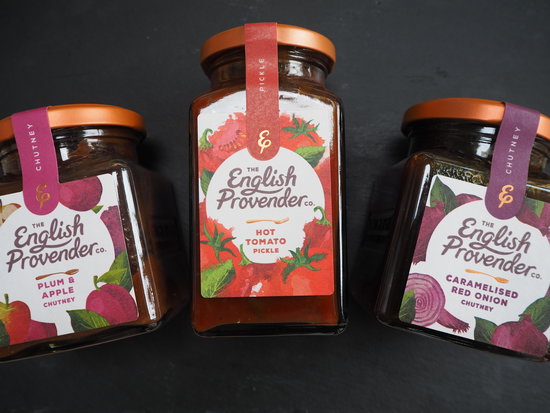Three jars of The English Provender Co. chutneys and pickle laid down on a dark slate background
