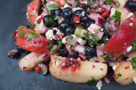 Close up of Chilli, Peach and Blueberry Salad served on a dark grey slate