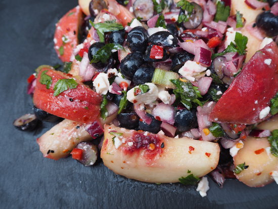Close up of Chilli, Peach and Blueberry Salad served on a dark grey slate