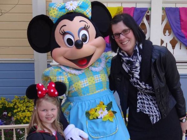 Mother and Daughter stood either side of Minnie Mouse character at Disneyland Paris