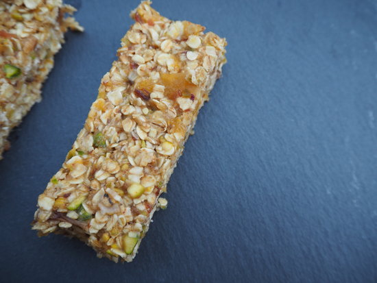 Rectangular no bake vegan date abd aoricot flapjack presented on a dark grey slate board