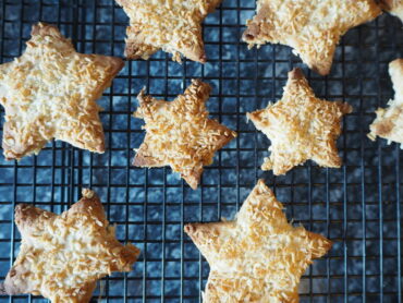 Cardamom coconut star biscuits on a wire baking rack