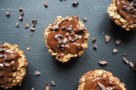 Close up of round triple chocolateprotein flapjack bites on a dark slate grey background
