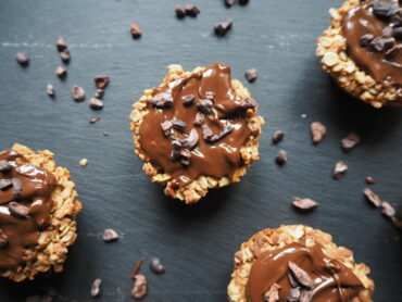 Close up of round triple chocolateprotein flapjack bites on a dark slate grey background