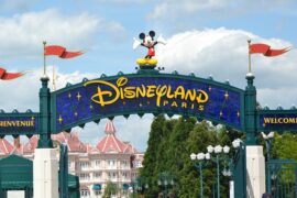 The Disneyland Paris welcome sign with the Disney Hotel in the background