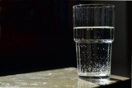 Glass of water set against a black background indicating the risk of contaminated water