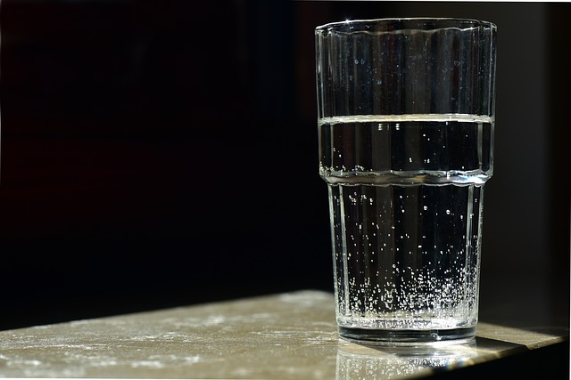 Glass of water set against a black background indicating the risk of contaminated water