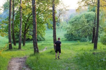 Man running through a grassy forest