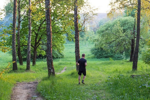 Man running through a grassy forest
