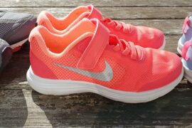 thee pairs of running trainers lined up in a row on some decking signifying how running may be one of the answers to the childhood obseoty problem in the uk