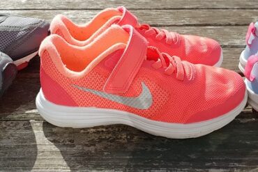 thee pairs of running trainers lined up in a row on some decking signifying how running may be one of the answers to the childhood obseoty problem in the uk