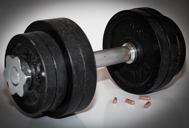 Dumbbells woth 4 capsules of steroid tablets next to them