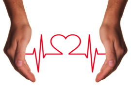 Two hands reaching down from the top of the picture. the background ios white and there is a red jagged heart beat line going between the two hands with the shape of a heart ion the centre of the image.