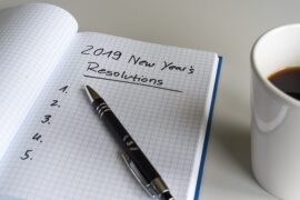 Notebooked opened up with the words 2019 New Year's Resolutions written and underlined on it.