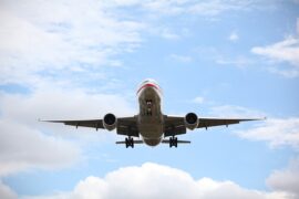 Front view of an aeroplane in a blue sky with white clouds