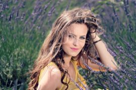 Long haired brunnete lady in her early thirties in a field of lavendar. She is a natural beauty.