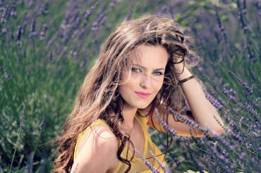 Long haired brunnete lady in her early thirties in a field of lavendar. She is a natural beauty.