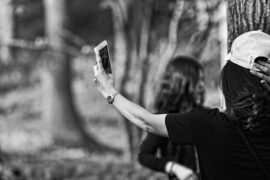 black and white photo of a long haired brunette lady taking a selfie