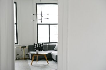 looking through a white doorway into a very modern wiary white living room that looks clean and fresh