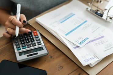 close up of a woman's hand using a calculator to work out her bills