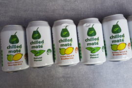 5 cans of Chilled Mate Yerba Energy Drinks laid flat in a diagonal line across a light slate grey background