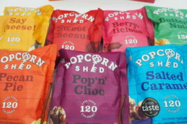 7 packets of Popcorn Shed gourmet popcorn laid out on a white background ready for review