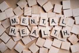 wooden scrabble tiles spelling out the words mental health