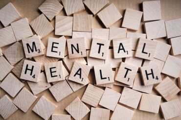 wooden scrabble tiles spelling out the words mental health