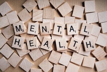 wooden scrabble tiles spelling out the words mental health