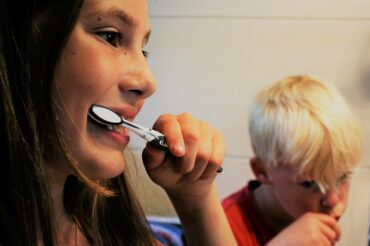 close up of two young children brushing their teeth