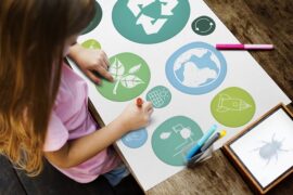 child making a collage of the ways she can help make her home more sustainable and environmentally friendky