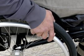 Close up of a mans hand on a wheelchair wheel