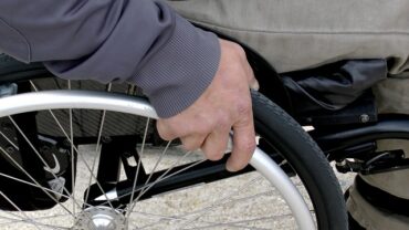 Close up of a mans hand on a wheelchair wheel