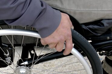 Close up of a mans hand on a wheelchair wheel
