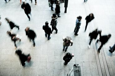 blurry photo of workers doing the daiily commute on a train station platform