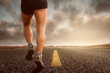 close up oof male runner from waist down from the back wearng black running compression shorts