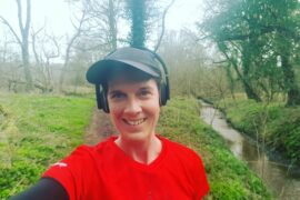 Becky Stafferton from chest up, takng a selfie of herself out running wiith headphones on listenong to music