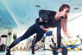 Female in gym doing strength training with dumbells